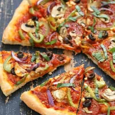 Vegane Pizza mit Gemüse, Pilzen und Oliven